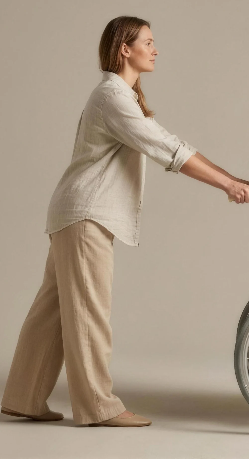 A care worker, hands on a wheelchair’s handles